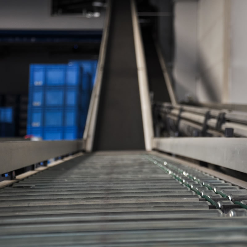 Conveyor in warehouse to transport inventory