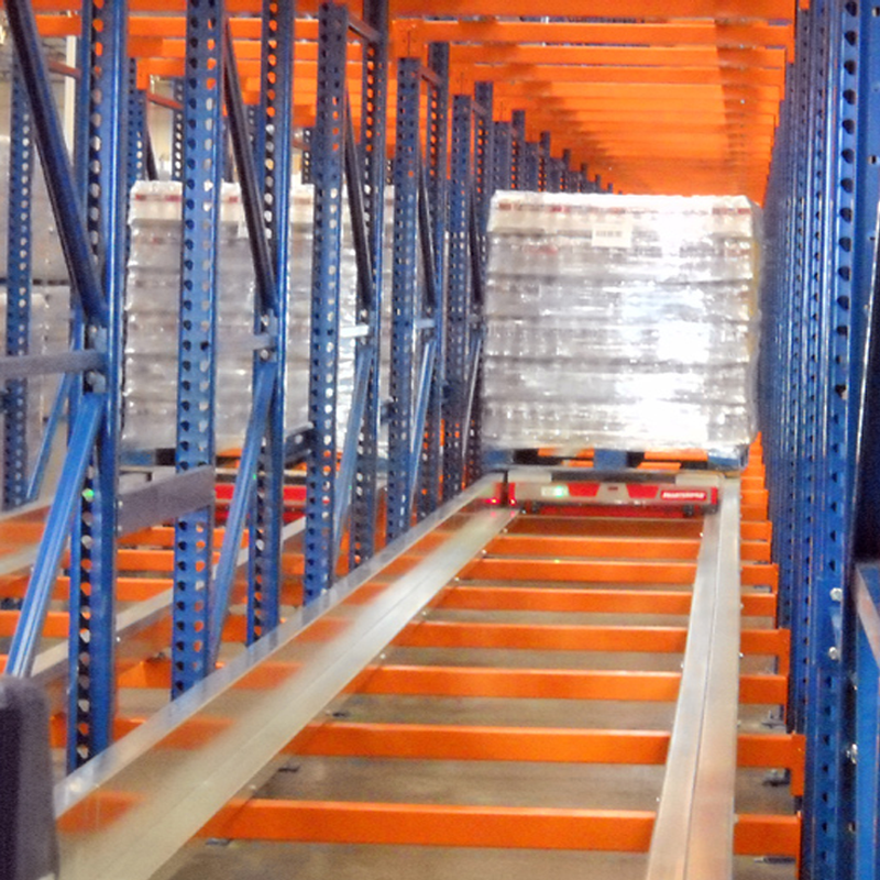 Semi automated pallet shuttle cart transporting pallets within industrial rack system.
